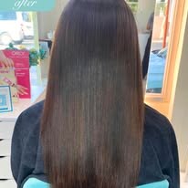 Client's long, glossy dark hair after a smoothing service at Glitter Professional Salon